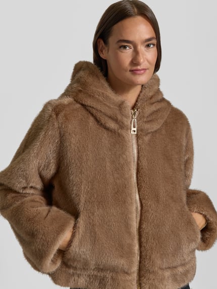 Frauenmodel trägt Jacke mit Kapuze und Kimonoärmeln von Liu Jo Sport in brauner Kunstfelloptik, Reißverschluss, gerader Schnitt, Nahaufnahme Oberkörper.