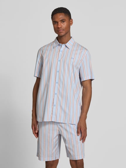 Männermodel trägt Regular Fit Freizeithemd aus reiner Baumwolle von Lacoste, gestreift, mehrfarbig, Popeline, Nahaufnahme Oberkörper.