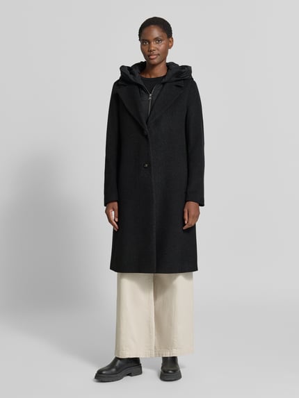 Frauenmodel trägt Mantel aus Schurwolle-Mix mit Kapuze von CINQUE in Schwarz, Straight Fit, Reverskragen, Reißverschluss und Knopfleiste, seitliche Eingrifftaschen, Ganzkörperansicht von vorne.