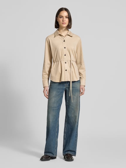 Frauenmodel trägt Bluse mit Bindegürtel Modell 'Zyla' von Someday in Beige, Hemdblusenkragen, taillierter Schnitt, Ganzkörperansicht von vorne.
