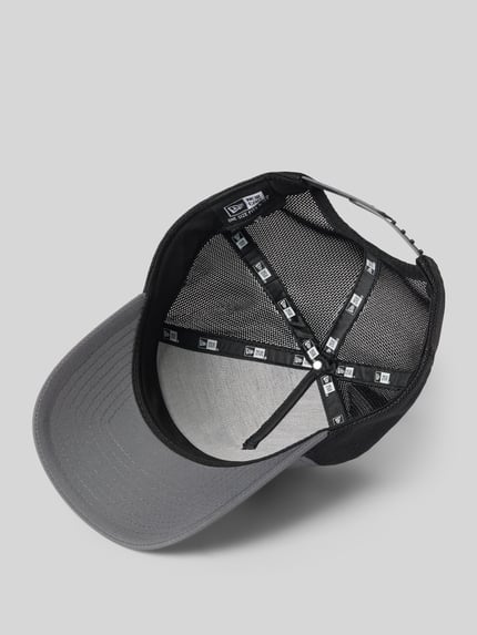 Produktfoto, Trucker Cap mit verstellbarem Riegel auf der Rückseite von New Era, grauer Schirm, schwarzes Mesh, Steppnähte, Statement-Applikation, Rückseite aus Mesh, verstärkter Schirm, verstellbarer Riegel