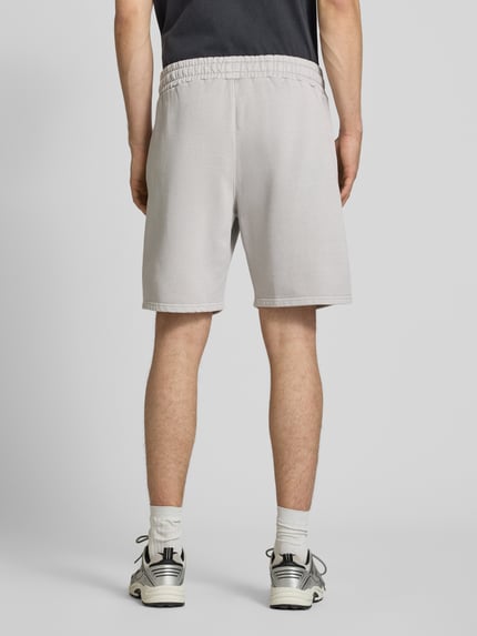 Männermodel trägt Regular Fit Shorts mit Logo-Stitching von Pegador aus Baumwoll-Mix, elastischer Bund, Ganzkörperansicht Rückansicht.