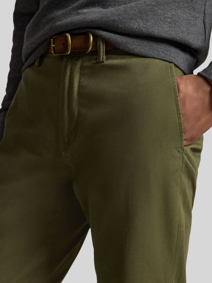Mężczyzna nosi proste spodnie z mieszanki bawełny 'Gerade Hose aus Baumwoll-Mix' od Polo Ralph Lauren w kolorze oliwkowym, zbliżenie na biodra.