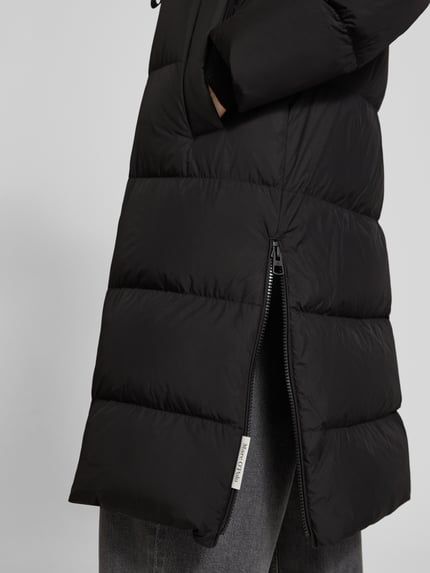 Frauenmodel trägt Daunenmantel mit Kapuze von MARC O’POLO, unifarben schwarz, Longline, Reißverschlüsse, Nahaufnahme Oberkörper.