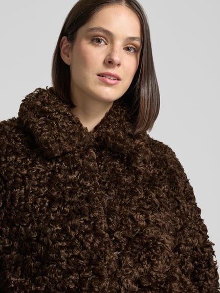 Vrouwenmodel draagt Jacke aus Kunstfell van closed, donkerbruin, brede opstaande kraag, recht pasvorm, imitatiebontstructuur, Nahaufnahme bovenlichaam. Ruglengte maat S: 60 cm, schouderbreedte: 56 cm, borstwijdte: 59 cm, mouwlengte: 66 cm