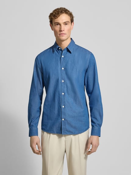 Männermodel trägt Regular Fit Freizeithemd mit Kentkragen Modell 'SPENSER' von Tiger Of Sweden aus reiner Baumwolle, Ganzkörperansicht von vorne.