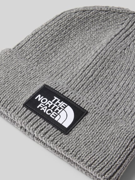 Produktfoto, Beanie in Ripp-Optik von The North Face, grauer Strick, elastischer Material-Mix, Label-Patch, breiter Umschlag.