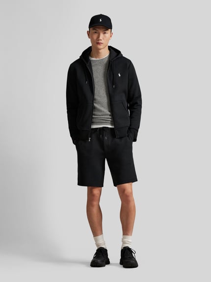 Männermodel trägt schwarze Regular Fit Sweatshorts aus Baumwoll-Mix von Polo Ralph Lauren mit elastischem Bund und Logo-Stitching, Ganzkörperansicht von vorne.