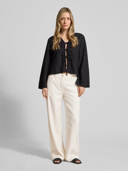 Frauenmodel trägt Wide Leg Pants aus Viskose-Mix mit Eingrifftaschen von FREE/QUENT, Damen Wide-Leg-Pants im Leinen-Viskose-Anteil, Modell 'Anya', helle Farbe mit kleinen Punkten, Knopf- und Reißverschluss, französische Eingrifftaschen, Gesäßleistentaschen, Ganzkörperansicht von vorne.