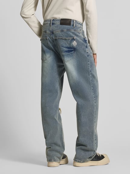 Männermodel trägt Straight Fit Jeans im Destroyed-Look von Don't Waste Culture, blauer Baumwoll-Elasthan-Mix, 5-Pocket-Design, Ganzkörperansicht Rückansicht.