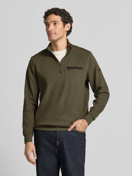 Männermodel trägt Sweatshirt mit Stehkragen und Reißverschluss von bugatti in Olivgrün, Baumwoll-Mix, Label-Detail, Ganzkörperansicht von vorne.