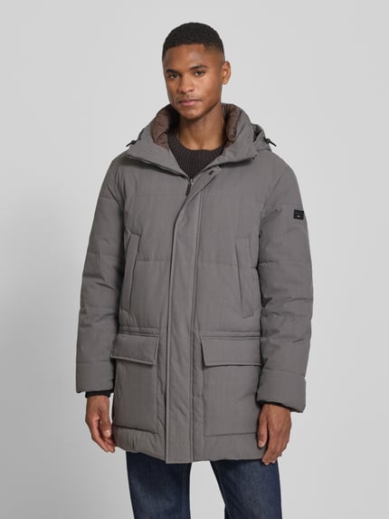 Männermodel trägt Parka mit Kapuze von bugatti, grau, Regular Fit, verdeckter Reißverschluss, Pattentaschen, Ganzkörperansicht von vorne.