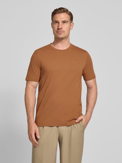 Männermodel trägt T-Shirt mit Label-Detail von bugatti in Braun, reine Baumwolle, gerader Schnitt, Rundhals, Nahaufnahme Oberkörper.