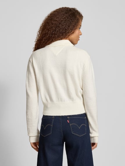 Vrouwenmodel draagt Cropped Strick-Poloshirt met Alpaka-Woll-Anteil Modell 'TJW FLUFFY POLO SWEATER' van Tommy Jeans, uni, regular fit, ribboorden, breisel, melange-optiek, lange mouwen, polokraag, label stitching, lichaamslengte cropped. Ganzkörperansicht achteraan.