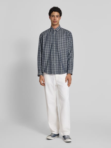 Männermodel trägt Regular Fit Jeans aus reiner Baumwolle Modell 'Jonah' von HUGO in Weiß, Denim-Optik, Ganzkörperansicht von vorne.