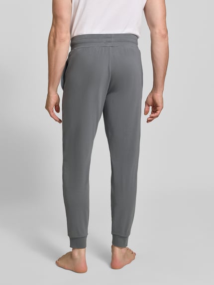 Männermodel trägt Regular Fit Sweathose aus katoenmix model 'Laze Pants CW' van HUGO, grijze tinten, Heren Sweathose, Ganzkörperansicht Rückansicht.
