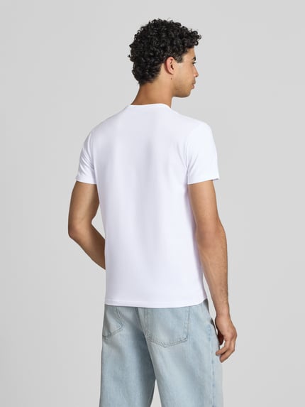 Männermodel trägt Slim Fit T-Shirt aus Baumwoll-Mix Modell 'ORIGINAL BASIC 3' von Pepe Jeans in Optik: Unifarben, Ganzkörperansicht Rückansicht.