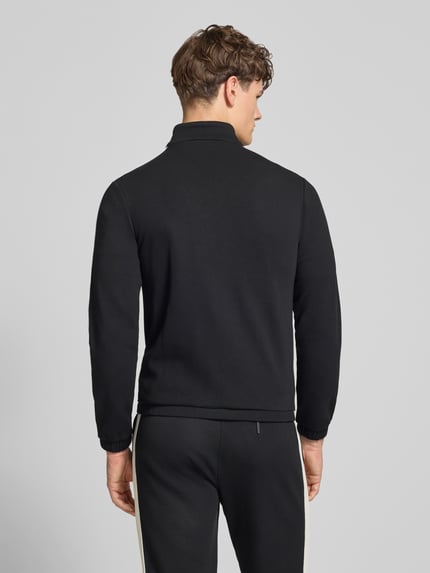 Męski model nosi Slim Fit Tracksuit mit Logo-Stitching Modell 'Egeo' od SERGIO TACCHINI, czarny, bawełniany, krój slim fit, elastyczne wykończenia, widok całej sylwetki od tyłu