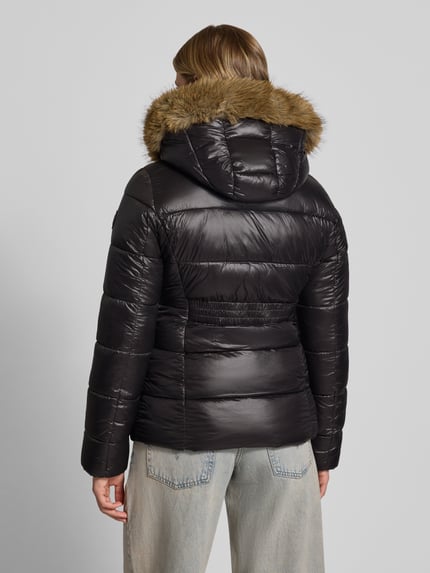 Frauenmodel trägt Steppjacke mit Kunstfell und Reißverschluss von REVIEW, schwarze Farbe, glatte Struktur, Rückenansicht, Ganzkörperansicht Rückansicht. Rückenlänge 65 cm, Schulterbreite 42 cm, Brustweite 48 cm, Ärmellänge 66 cm.