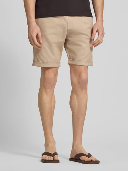 Männermodel trägt Shorts mit elastischem Bund und Gesäßtasche von MCNEAL im Regular-Fit aus Material-Mix mit Viskose-Anteil, Ganzkörperansicht von vorne.