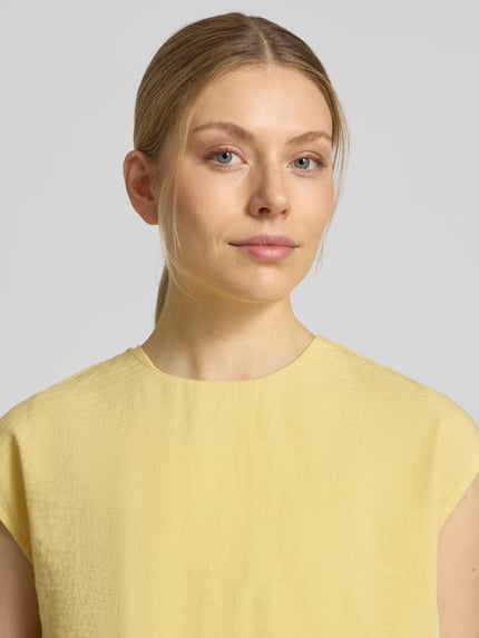 Vrouwenmodel draagt Bluse mit Rundhalsausschnitt und Kappärmeln van Jake*s Collection in lichtgeel, rechte fit, fijne textuur, close-up bovenlichaam.