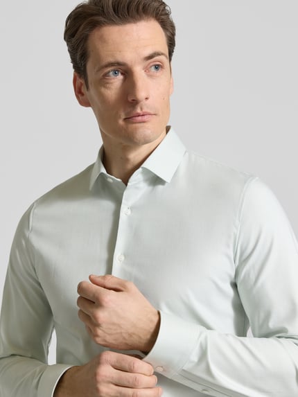 Männermodel trägt Super Slim Fit Business-Hemd Modern Kent Uni Twill von OLYMP No. Six, elastischer Baumwoll-Mix, Nahaufnahme Oberkörper.
