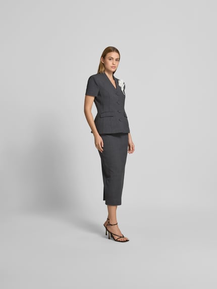 Frauenmodel trägt Midikleid mit Woll-Anteil von Self-Portrait in Dunkelgrau, Taillierte Passform, Florale Applikation, V-Ausschnitt, Kurzärmelig, Gesamtlänge 127 cm, Nahaufnahme Ganzkörperansicht von vorne.