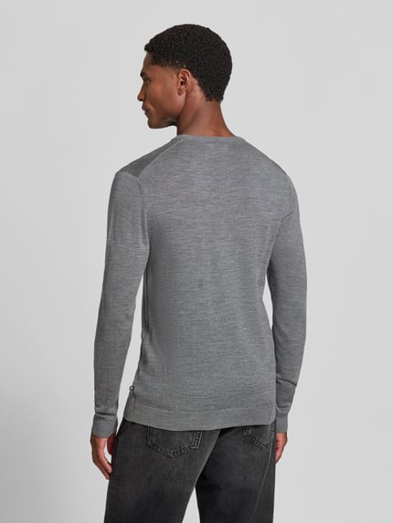 Męski model nosi sweter wełniany z prostym krojem Matinique Strickpullover mit gerippten Abschlüssen Modell 'Margrate', szary kolor, prążkowane wykończenia, okrągły dekolt, długość tyłu w rozmiarze M: 63 cm, długość rękawów w rozmiarze M: 69 cm, widok całej sylwetki z tyłu.