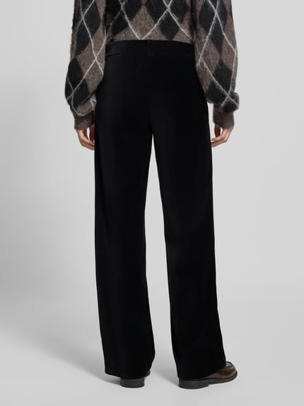 Frauenmodel trägt schwarze Regular Fit Cordhose mit Bundfalten Modell 'MAINE' von BRAX, Struktur, seitliche und Gesäßtaschen, Ganzkörperansicht Rückansicht.