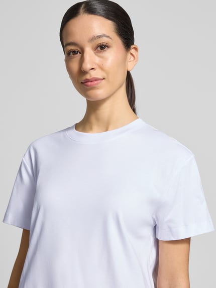 Frauenmodel trägt T-Shirt mit Rundhalsausschnitt von Stefanel in Weiß, reine Baumwolle, gerader Schnitt, Nahaufnahme Oberkörper.