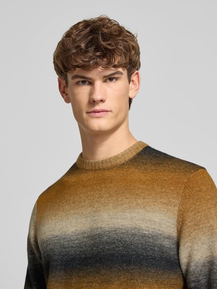 Männermodel trägt Regular Fit Strickpullover mit Baumwoll-Anteil Modell 'BERTIL' von Only & Sons, Optik: Allover-Muster, Rundhals, Langarm, gerippte Abschlüsse, Materialverarbeitung: Strick, warme Farbverläufe, Nahaufnahme Oberkörper.