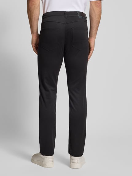 Männermodel trägt Stoffhose mit französischen Eingrifftaschen von Christian Berg Men in zwart, rechte snit, grote zakken, Ganzkörperansicht Rückansicht.