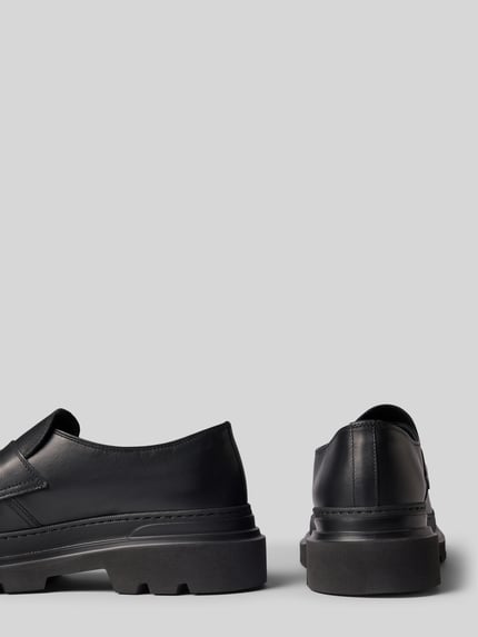 Produktfoto, schwarze Loafers aus echtem Leder Modell 'Harvell' von Antony Morato mit profilierter Sohle auf grauem Hintergrund. Kontext: Herren Loafers, abgerundete Passform, Absatzhöhe und Schafthöhe 6 cm, Schaftweite 11 cm bei Größe 44.
