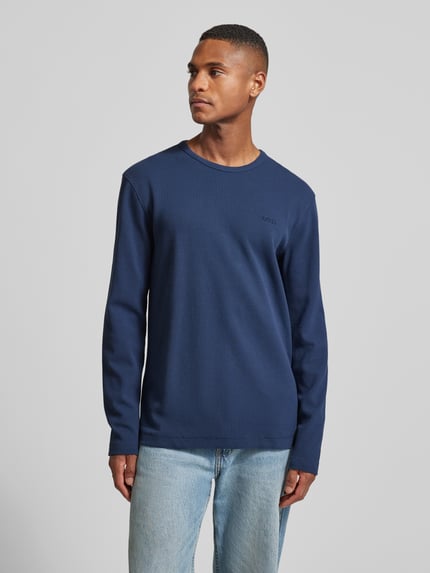 Männermodel trägt Regular Fit Langarmshirt aus Baumwoll-Mix Modell 'TEMPESTO' von BOSS Orange in Blau, Waffel-Optik, Ganzkörperansicht von vorne.