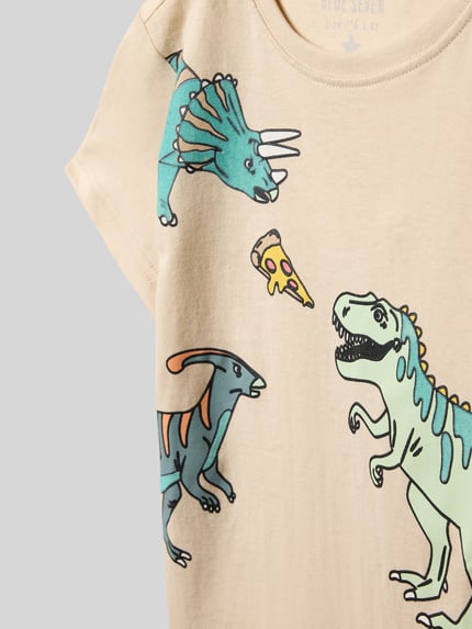Mädchen trägt Regular Fit T-Shirt mit Allover-Motiv-Print von Blue Seven aus reiner Baumwolle, Rundhalsausschnitt, Nahaufnahme Oberkörper.