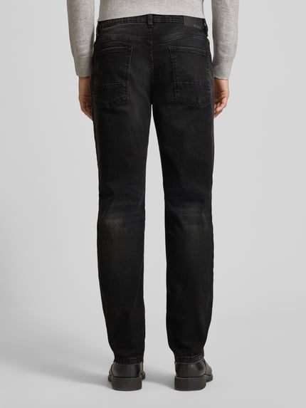 Männermodel trägt Regular Fit Jeans im Used-Look von MCNEAL in Schwarz mit Baumwoll-Mix und Stretch-Anteil, Ganzkörperansicht Rückansicht.