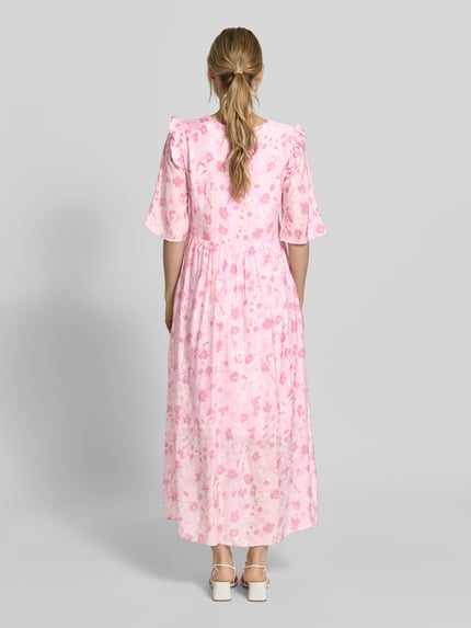Vrouwenmodel draagt maxi-jurk uit viscosemix met model 'Melie' van mbyM, bloemen all-over print, getailleerd, met ruches, halflange mouwen, ruglengte maat S 131 cm, borstwijdte maat S 44 cm, mouwlengte maat S 35 cm, geheelbeeld achteraanzicht.