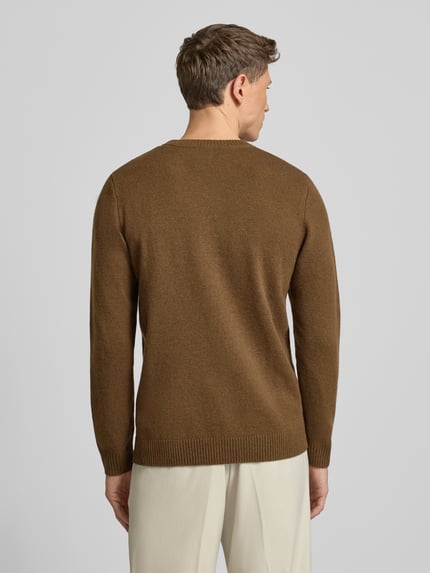 Männermodel trägt Strickpullover aus reiner Lammwolle Modell 'Tay' von Wood Wood in Braun, Regular-Fit, Rückenansicht, Rückenlänge 72 cm.