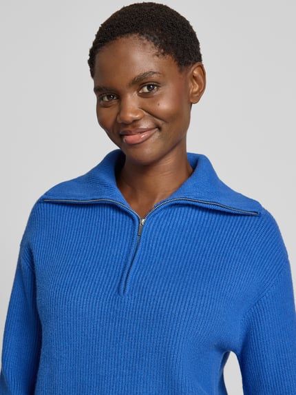 Frauenmodel trägt Troyer aus Viskose-Mix mit gerippten Abschlüssen Modell 'RIZON' von MANGO in Blau, Nahaufnahme Oberkörper, Regular Fit.