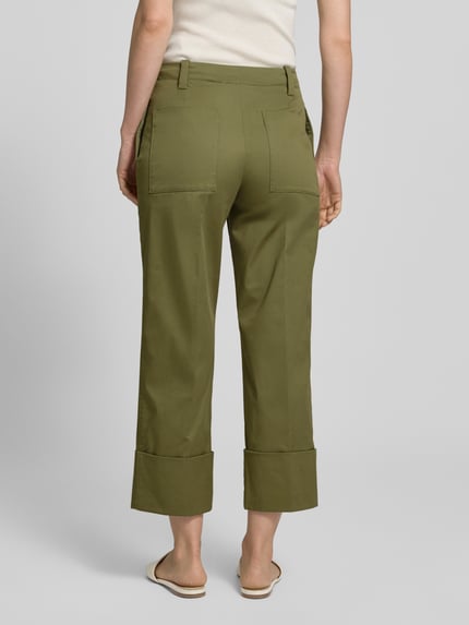 Kobiece modelka nosi spodnie z mieszanki bawełny z dodatkiem streczu, model 'PANTALONE' od Stefanel, zakładka na dole, krój straight fit, wpuszczane kieszenie z przodu, kieszenie z tyłu, zapięcie na haftkę i zamek błyskawiczny, szerokość w rozmiarze 36: 35 cm, długość wewnętrzna nogawki w rozmiarze 36: 66 cm, oliwkowy kolor, widok całej sylwetki od tyłu.
