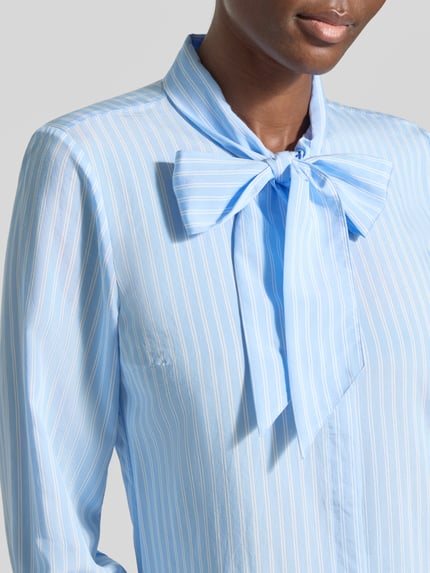 Frauenmodel trägt Regular Fit Hemdbluse aus Viskose-Mix von MORE & MORE, Zierkragen, hellblau mit weißen Streifen, Nahaufnahme Oberkörper.