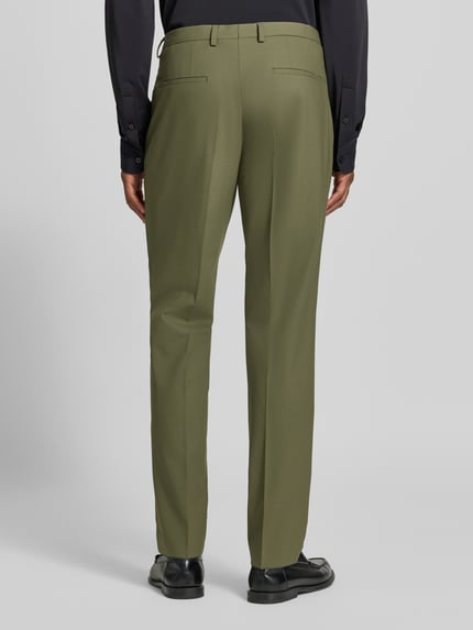 Männermodel trägt olivgrüne Super Slim Fit Anzughose aus Woll-Mix Modell 'Hesten253X' von HUGO, Herren Anzughose, Ganzkörperansicht Rückansicht.