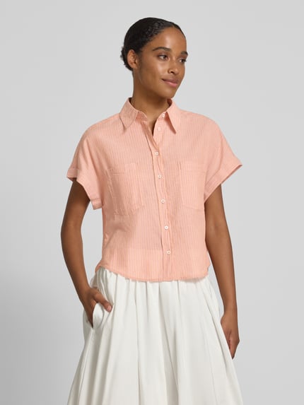 Vrouwenmodel draagt Boxy Fit Hemdbluse aus reiner Baumwolle van Marc O'Polo met all-over motief, boxy fit, overhemdkraag, borstzakken, puur katoen, gestreept patroon, korte mouw, plooien op de achterpas, mouwboord met omslag, lichte textuur, zachte perzikkleur, vooraanzicht bovenlichaam.