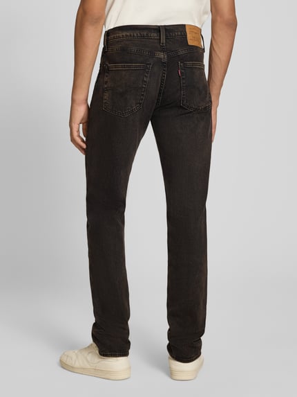 Mężczyzna nosi ciemnobrązowe jeansy Slim Fit Jeans aus Baumwoll-Mix Modell '511® SLIM' von Levi's®, Herren Slim Fit Jeans, całkowity widok z tyłu.