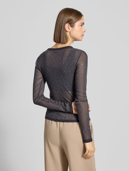Frauenmodel trägt Slim Fit Longsleeve mit Strasssteinbesatz von Gina Tricot, schwarzes semitransparentes Material, Rückansicht, Ganzkörperansicht.