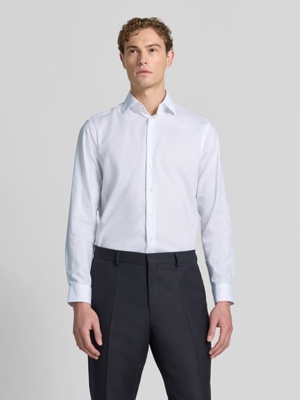 Männermodel trägt Regular Fit Business-Hemd mit Kentkragen von Christian Berg Men in Weiß, Reine Baumwolle, Durchgängige Knopfleiste, Langärmelig, Ganzkörperansicht von vorne