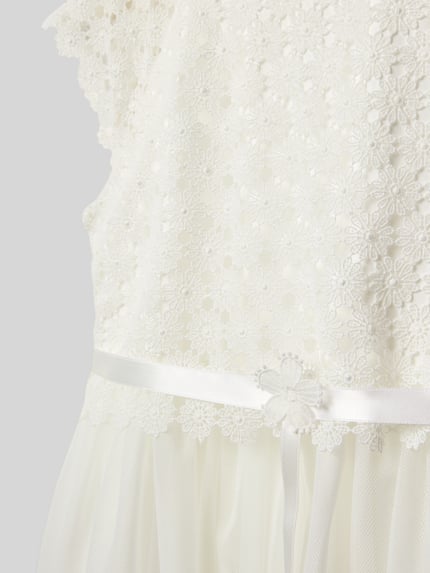Meisje draagt Regular Fit Jurk met bloemen stitching van Weise, semi-transparant design, met onderrok, detailopname bovenlichaam.