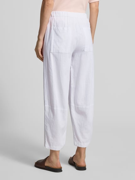 Frauenmodel trägt Stoffhose aus Leinen-Viskose-Mix Modell 'Lava' von FREE/QUENT in Weiß, Relaxed-Fit, elastischer Bund, Rückansicht Ganzkörperansicht. Bundweite bei Größe S: 37 cm, Innenbeinlänge bei Größe S: 66 cm.