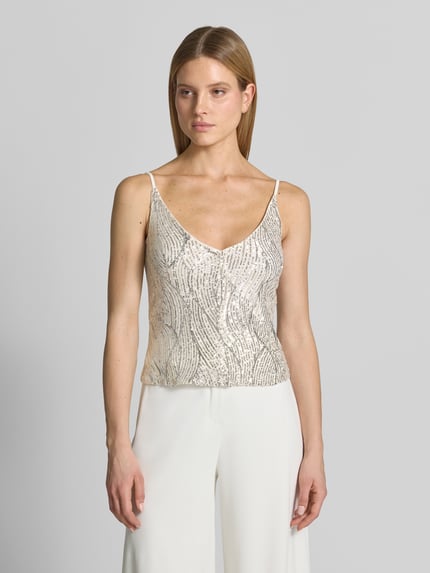 Vrouwenmodel draagt Top met V-hals en pailletten van Swing in materiaalmix met stretch, regular fit, ruglengte bij maat 36: 28 cm, kleur licht, rechte vormen, glanzende textuur. Ganzkörperansicht von vorne.