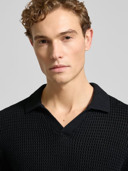 Männermodel trägt Strickpullover mit gerippten Abschlüssen van MCNEAL, zwarte katoen, resortkraag, V-hals, Nahaufnahme Oberkörper.
